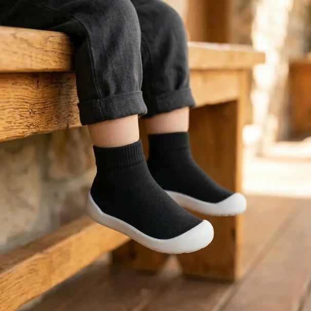 Kleinkind zieht sich seine Sockenschuhe selbst an